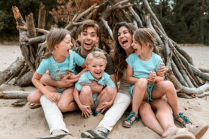 Gezinsfoto van een gezin met jonge kinderen in de duinen, gemaakt tijdens een gezinsshoot bij Moment Fotografie