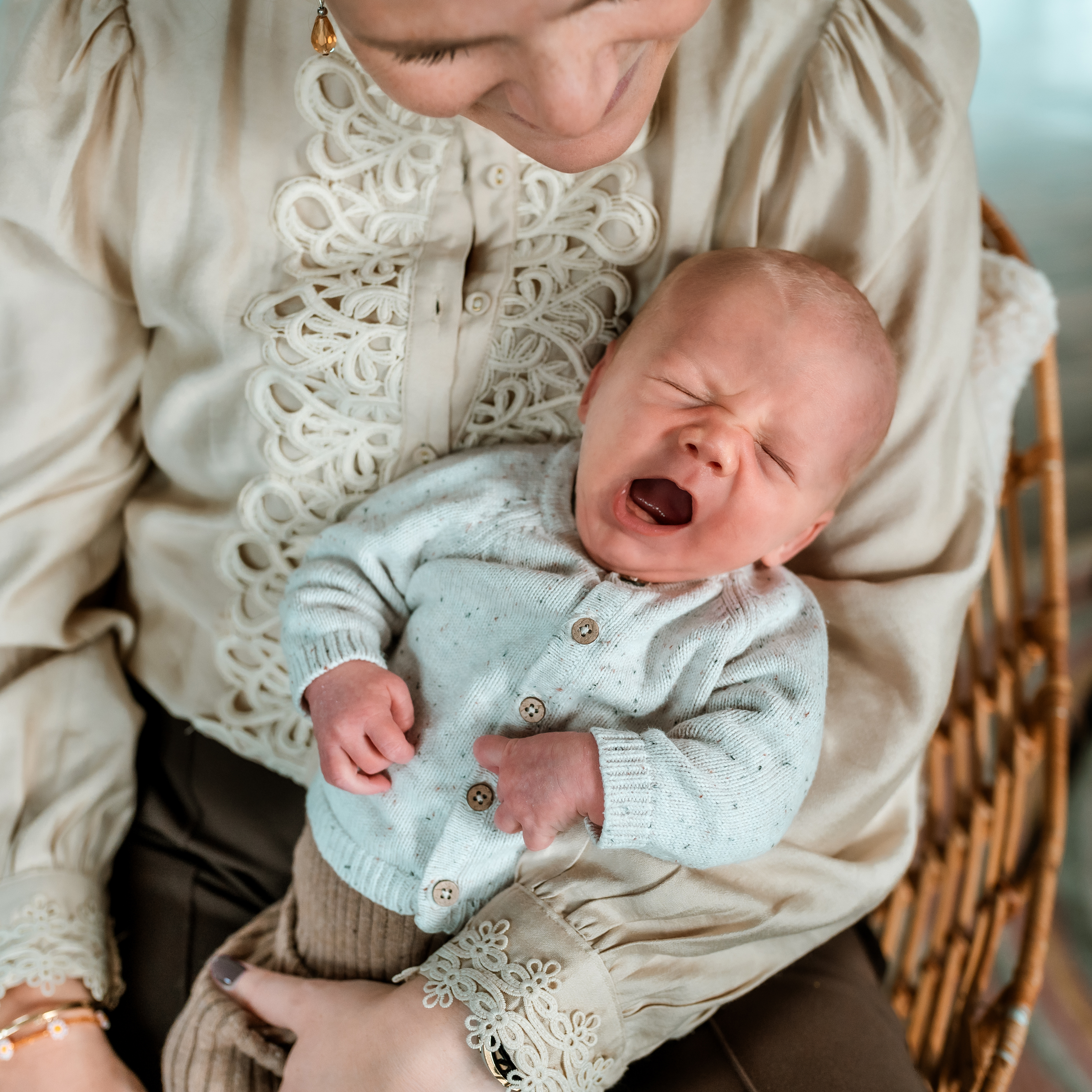 Gapende newborn op schoot bij zijn moeder